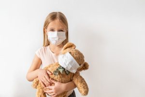 Child and teddy bear wearing face masks